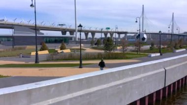 PETERSBURG, RUSSIA - 22 Mayıs 2020: siyah kazaklı ve gri pantolonlu bir adam gezinti güvertesi boyunca koşuyor. Şehrin üzerinde İHA uçuşu.