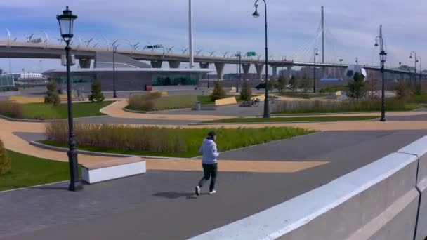 聖ペテルスブルグ ロシア 5月22 2020 灰色のセーターの女の子が遊歩道に沿って走っています 街を飛行中 — ストック動画