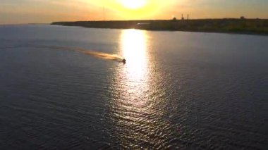 PETERSBURG, RUSSIA - 24 Mayıs 2020: bir jiroskopi güzel mavi denizi gün batımında keser. Bir jet ski üzerinde dinlenen insanların hava videosu..