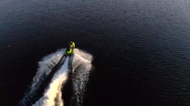 PETERSBURG, RUSSIA - 24 Mayıs 2020: bir jiroskopi güzel mavi denizi gün batımında keser. Bir jet ski üzerinde dinlenen insanların hava videosu..