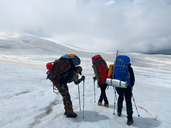 Sırt Çantaları Yürüyüş Direkleri Olan Yorgun Dağcı Elbrus Yamaçlarında Duruyor — Stok fotoğraf