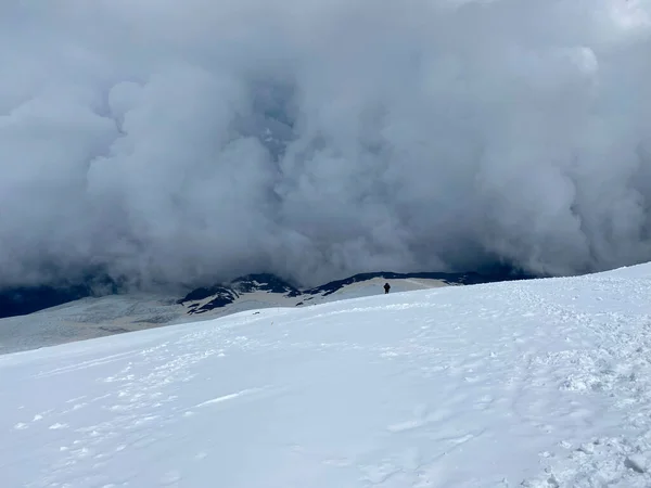 배낭을 올라가거나 장대를 눈덮인 걷는다 아름다운 엘브루스 북부의 눈덮인 경사지입니다 — 스톡 사진