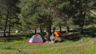 Bir yaz günü ormandaki çadırlar için kamp alanı. Kuzey Elbrus bölgesinin yeşil yamaçları.