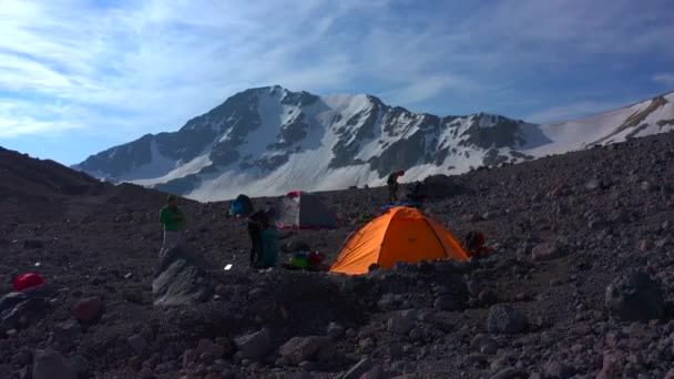 帐篷营地在Elbrus山前面旅行者收集他们的背包 Elbrus北部地区的雪质岩石斜坡 山区冬季景观 — 图库视频影像