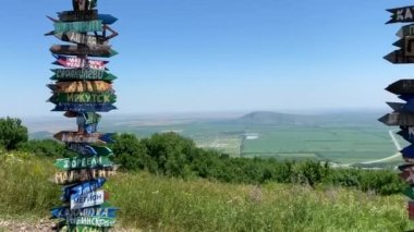 Pyatigorsk 'taki Mashuk Dağı' nın tepesindeki gözlem güvertesinde. Tabaklar - farklı şehirlerin ve ülkelerin isimlerinin yazılı olduğu işaretler. 1000 metre yükseklikten yaz manzarası.