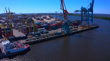 Nehir kıyısındaki bir dizi inşaatın ya da yük vincinin yanında duran bir mavnanın havadan görüntüsü. Gemi Kanonersky Adası 'na yanaşıyor. Su mavnaları ve nakliye araçlarıyla sanayi limanı.