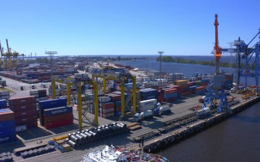 Aziz PETERSBURG, RUSSIA - 17 Temmuz 2020: nehir kıyısındaki bir dizi inşaat veya kargo vincinin havadan görüntüsü. Gemi Kanonersky Adası 'na yanaşıyor. Su mavnaları ve nakliye araçlarıyla sanayi limanı.