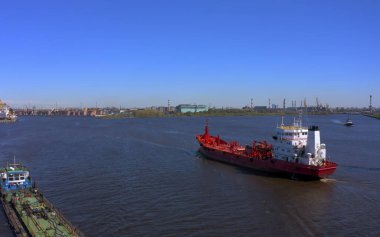 Nehir kıyısındaki bir dizi inşaatın ya da kargo vincinin havadan görüntüsü ve yakınlarda bir tekne var. Gemi Kanonersky Adası 'na yanaşıyor. Su mavnaları ve nakliye araçlarıyla sanayi limanı.