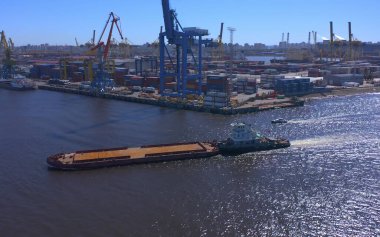 Aziz PETERSBURG, RUSSIA - 17 Temmuz 2020: nehir kıyısında bir sıra inşaat veya kargo vincinin yakınlarda yelken açtığı hava görüntüsü. Gemi Kanonersky Adası 'na yanaşıyor. Su mavnaları ve nakliye araçlarıyla sanayi limanı.