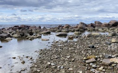 Kaya sahili. Küçük dalgaları olan güzel bir deniz. Dalgalar taşlara vurur.