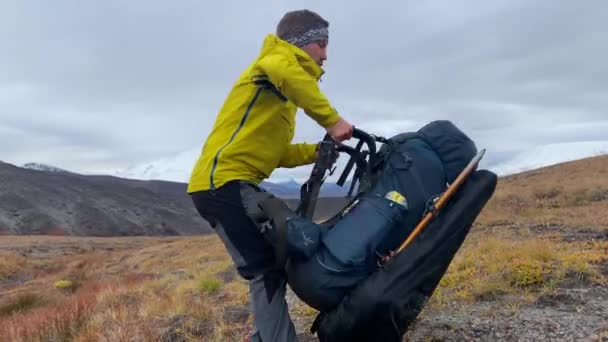 Kamchatka Peninsula Russia September 2020 穿着黄色夹克的人把远征背包放在上面 在堪察加半岛火山背景下 一个背负背包和远足杆子的游客 — 图库视频影像