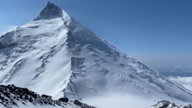 Karla kaplı Kamen yanardağının ve çevresinin 3900 metre yükseklikteki havadan görüntüsü. Şiddetli kar yağışı. Kamçatka Yarımadası 'na git..