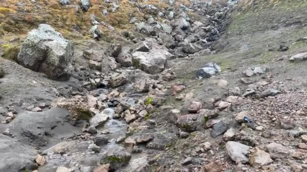 Horský potok s čistou vodou. Po kamenech stéká pitná voda. Přírodní zdroj čisté vody v horách. Cesta na poloostrov Kamčatka.