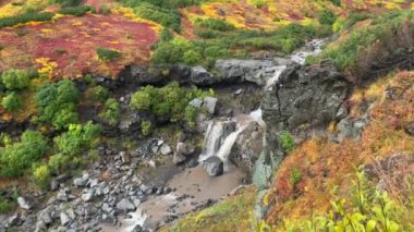 İki aşamalı bir şelalenin nefes kesici manzarası küçük bir dağ nehrine dönüşüyor. Güzel bir yer. Kamçatka Yarımadası 'na git. Çarpıcı sonbahar manzarası.