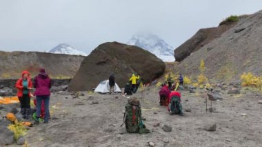 Bir grup turist kampı kapatıp gitmeye hazırlanıyor. Klyuchevskoy volkan parkında gezinti. Kamçatka Yarımadası 'na git..