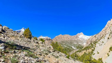 Tacikistan 'ın hayran dağlarına tırmanmak. Gezinti ve yürüyüş. Asya 'nın dağlarında temiz havada bir yürüyüş. Kayalık tepeler, tepeler ve kayalıklar seyrek yeşil çalılarla kaplı.