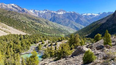 Tacikistan 'daki Alaudin Gölleri' nin güzel vadisine nefes kesici bir manzara. Karla kaplı sıradağlar, yeşil tepeler ve uçurumlar, el değmemiş orman ve güzel doğa..