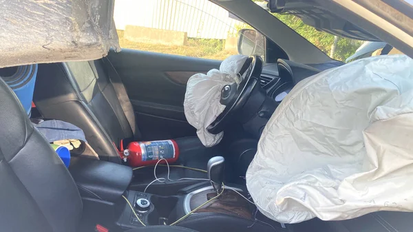 Bir araba kazasındaki iç mekan görüntüsü. Yırtık hava yastığı ve yangın söndürücü olan bir araba. Yoldaki kazalara karşı sigorta. Araba hasar görmüş.