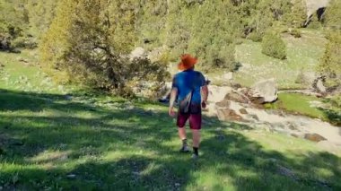 Kovboy şapkalı bir adam fırtınalı bir dağ nehri boyunca yürür. Alaudinsky göllerine yolculuk. Tacikistan 'daki uzak yerlere git. Güzel yeşil park