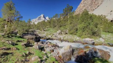 Tacikistan 'daki Alaudin Gölleri' nin güzel vadisine nefes kesici bir manzara. Karla kaplı sıradağlar, nehirler, yeşil tepeler ve uçurumlar, bakir orman ve güzel doğa..