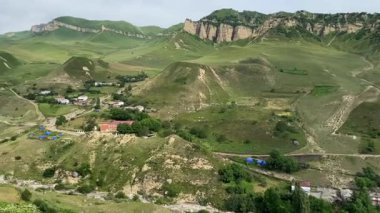 Azerbaycan 'ın pitoresk bölgesinde bulunan Kuzun köyü. Yeşil yamaçlı yüksek dağlar ve kayalık oluşumlar. Ön planda bir arı var.