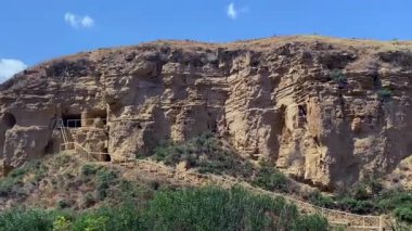 Diri Baba 'nın mozolesinin yanındaki kayadaki birkaç mağaranın havadan görüntüsü. Keşişler ve dini figürler mağaralarda yaşıyordu. Eğim çıplak ve kayalık. Azerbaycan 'a bir gezi.