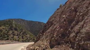 Tacikistan 'ın göbeğindeki pitoresk bir dağ geçidinde bir gezi. İçinde asfalt yol olan bir dağ sırası. Karla kaplı tepeler ve yeşil yamaçlar