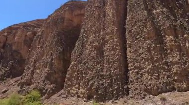 Terkedilmiş kırsal bir yolda nehir boyunca uzanan sıradışı kumlu kayalar. Tacikistan 'a hoş geldiniz. Seyahat ve turizm. Dünya üzerinde ulaşılması zor yerlerde bir araba yolculuğu.