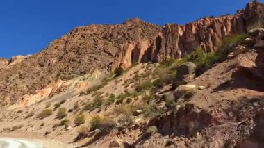 Tacikistan dağlarında bir toprak yol gezisi. Issız çalıları olan kayalık bir dağ. Yol ıssız ve ıssız. Vahşi dağ manzarası