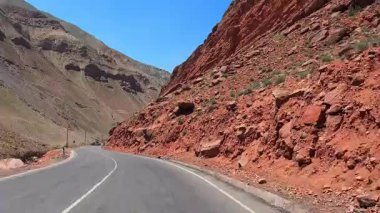 Tacikistan 'daki Varzob vadisinde bir gezi. Virajlı yol, kırmızı uçurumlar ve tepeler boyunca uzanır. Tacikistan 'ın simgesi.