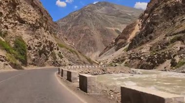 Tacikistan 'ın Varzob vadisinde tehlikeli virajlarla dolu uç bir yolda gitmek. Bir dağ nehri otoyol boyunca akar. Manzara huzurlu ve huzurlu.