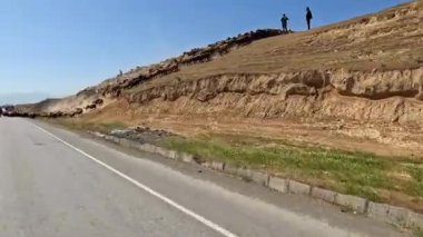 Khujand, Tacikistan 8 Mayıs 2025: Asyalı çoban sürüsü yola çıktı. Bir beyaz, kahverengi ve kara koyun sürüsü yamaçtan aşağı koşuyor. Kırsal yaşam