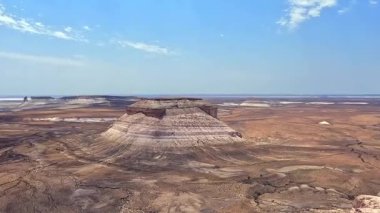 Ortasında büyük bir kaya oluşumu olan eşsiz bir çöl manzarasının havadan görüntüsü. Bozzhyra yolu Kazakistan 'ın olağanüstü doğal bir anıtıdır.