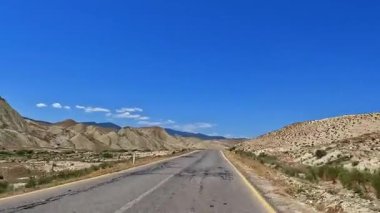 Azerbaycan 'ın pitoresk manzarasındaki otoyol manzarası. Mavi gökyüzü ve kumlu tepeleri olan Paved yolu. Yol boş ve üzerinde hiç araba yok.