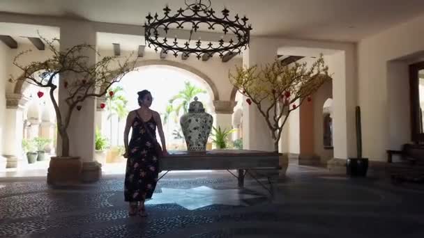 Frau im Sommerkleid auf Tisch mit Vase in Lobby des karibischen Luxus-Resorts — Stockvideo