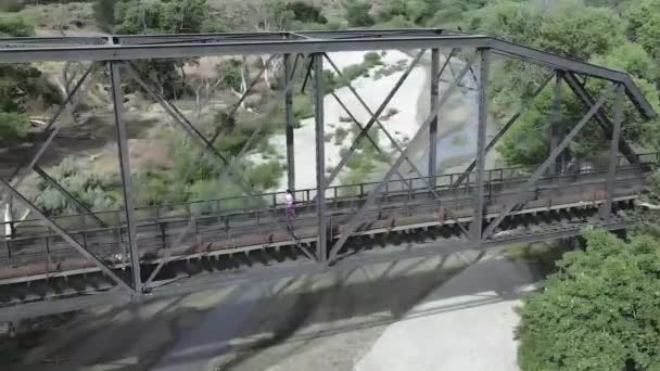 Corredor femenina corriendo sobre el río en el puente en el campo americano, vista aérea Metraje De Stock