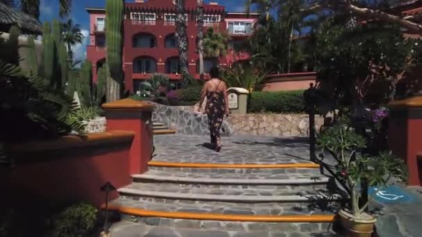 Vrouwelijke wandeling door Sheraton Hotel, het verkennen van buiten binnentuin tuinen Cabo — Stockvideo