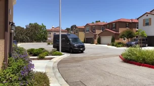 Amazon delivery van, driving through neighborhood of homes with packages Stock Footage