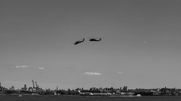 Two helicopters flying around New York City