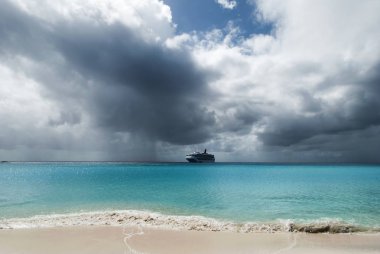 Yakındaki ıssız sürüklenen cruise gemi ada Half Moon Cay bulutlu gökyüzü altında (Bahamalar).