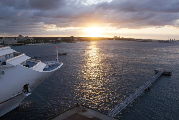 The view of a moored cruise ship with a sunset view over Nassau city (Bahamas).