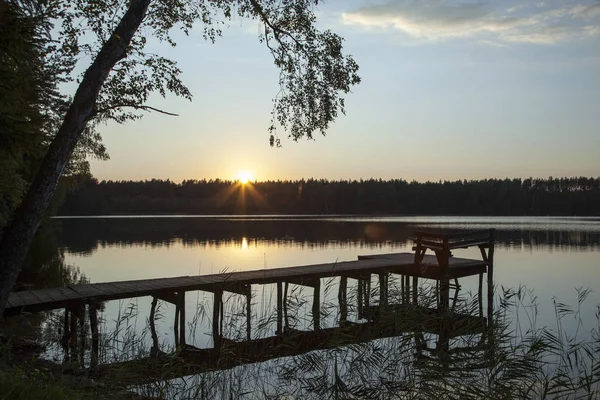 Pôr do sol do lago com um cais de madeira — Fotografia de Stock