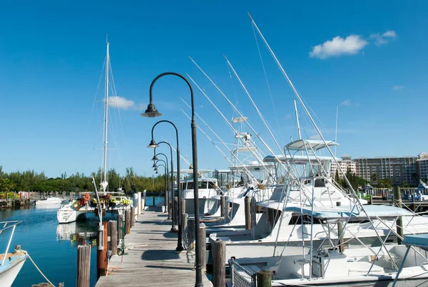 The wooden pier and white color boats in Freeport resort town marina on Grand Bahama island (Bahamas).