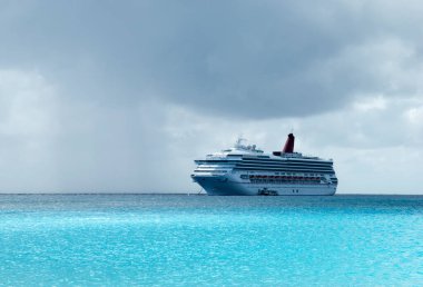 Half Moon Cay (Bahamalar) yakınlarında yağmurlu gökyüzünün altında sürüklenen yolcu gemisi).