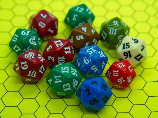 Yellow role-playing board with several colored dice on top in a pentagonal shape
