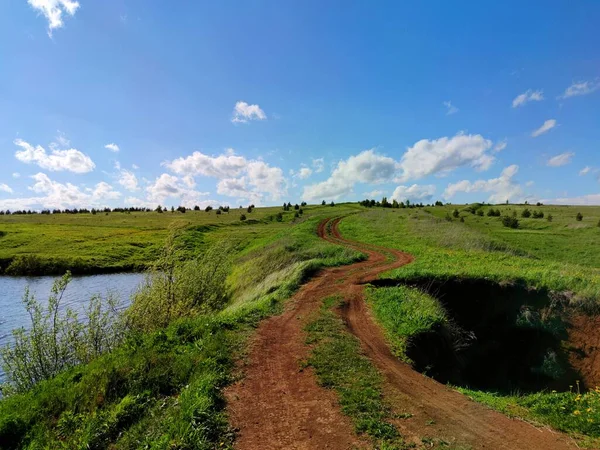 Rural Winding Road Uphill Field Lake Ravine Blue Sky Clouds — Stock Photo, Image