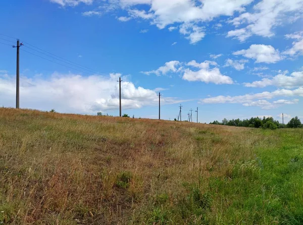 Postes Línea Energía Campo Contra Cielo Azul Con Hermosas Nubes —  Fotos de Stock