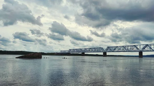 暗い曇り空を背景に川に架かる鉄橋 — ストック写真