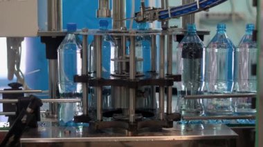 Şişe su üretimi. Plastik su şişelerindeki kapakların otomatik bükülmesi.