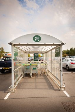 Güneşli bir günde otoparkta Morrison süpermarketinin alışveriş masası neredeyse bomboş..